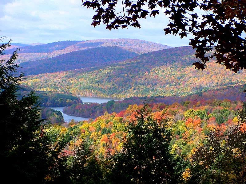 Autumn foliage across the Catskill mountains, with a lake nestled in the valley
